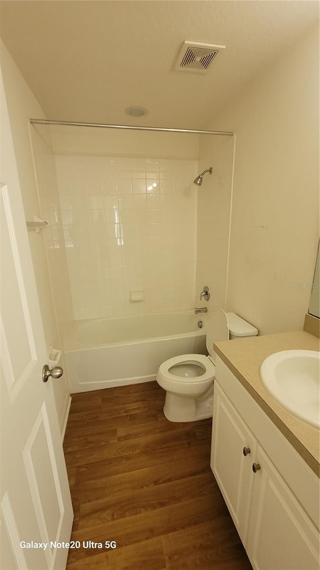 full bathroom with wood-type flooring, vanity, toilet, and tiled shower / bath