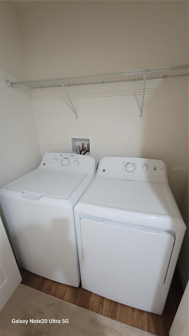 laundry room with hardwood / wood-style flooring and washer and clothes dryer