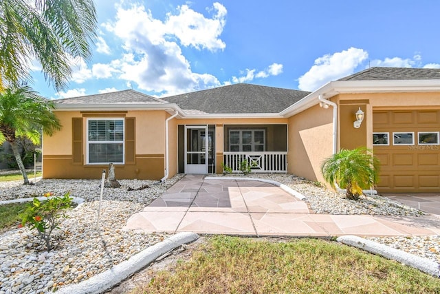 single story home featuring a porch and a garage