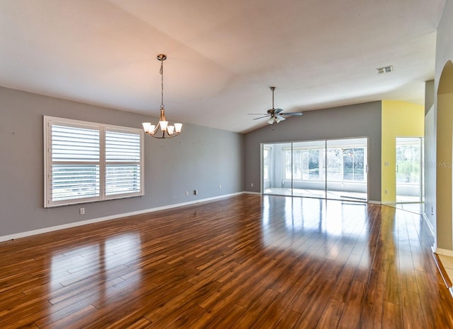 spare room featuring ceiling fan with notable chandelier, vaulted ceiling, and dark wood-type flooring