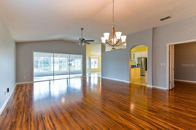 spare room with ceiling fan with notable chandelier, dark hardwood / wood-style floors, and lofted ceiling