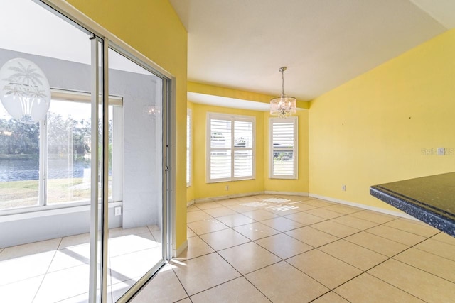 unfurnished dining area with a notable chandelier and light tile patterned flooring