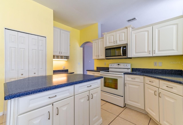 kitchen with electric stove, white cabinetry, and light tile patterned flooring