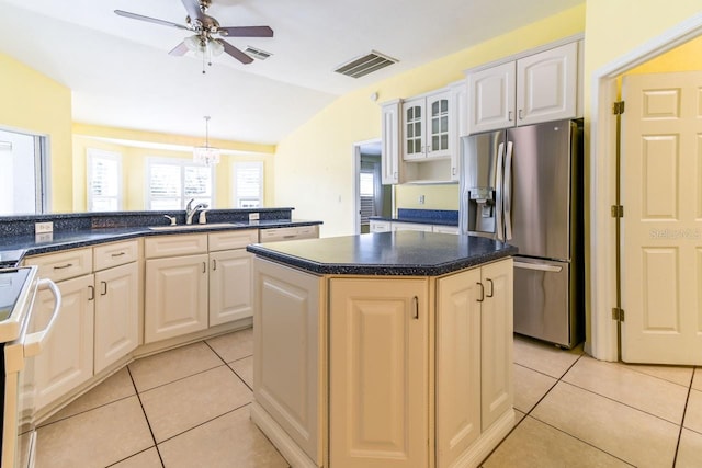 kitchen with sink, stainless steel fridge, vaulted ceiling, a kitchen island, and white stove