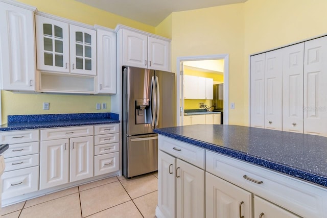 kitchen featuring white cabinets, stainless steel fridge with ice dispenser, and light tile patterned flooring