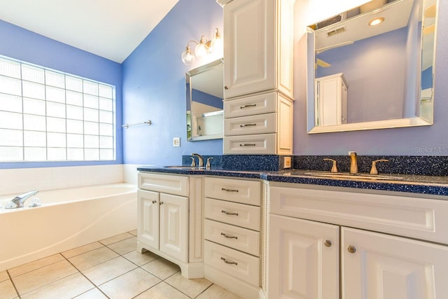 bathroom featuring tile patterned floors, vanity, and a tub to relax in