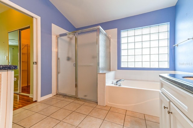 bathroom with tile patterned floors, vanity, plus walk in shower, and vaulted ceiling