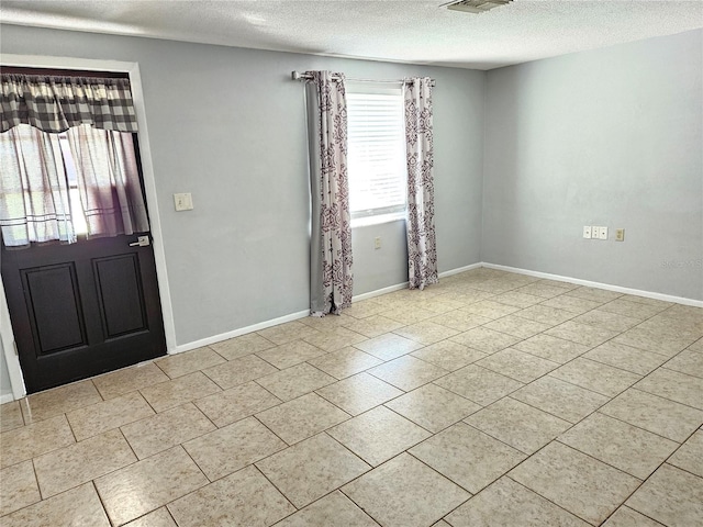 entryway featuring light tile patterned floors and a textured ceiling