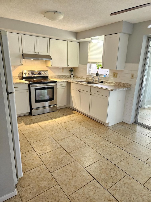 kitchen with white cabinets, sink, stainless steel electric range oven, a textured ceiling, and white fridge