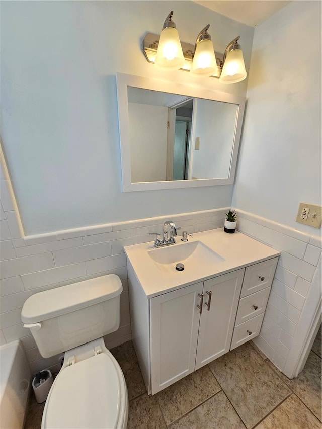 bathroom with tile patterned flooring, vanity, tile walls, and toilet