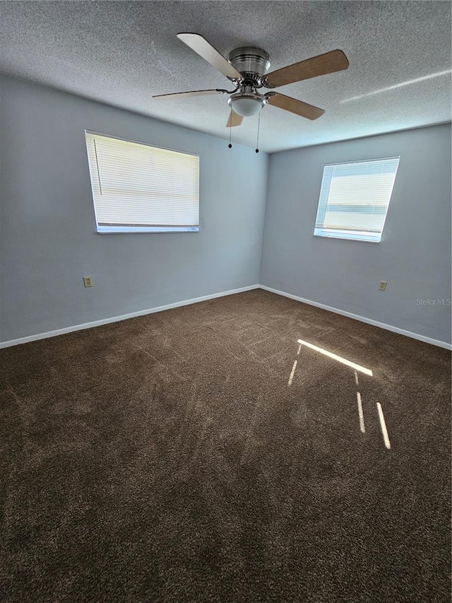 carpeted spare room featuring ceiling fan and a textured ceiling