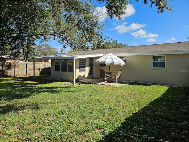 rear view of house featuring a yard and a patio area