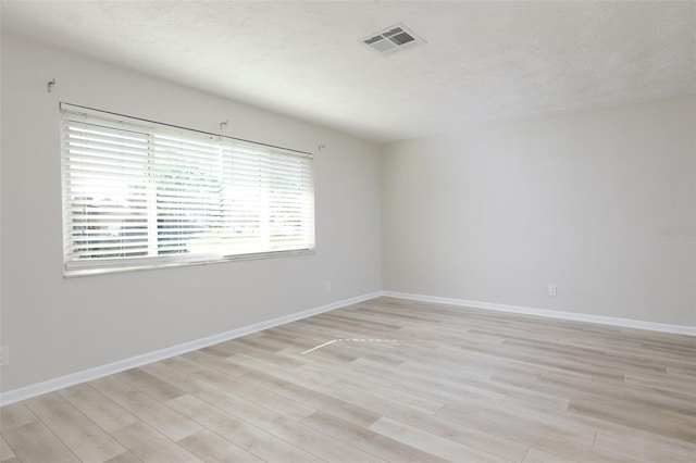 6701 13th Ave N, Saint Petersburg, FL 33710 - spare room featuring light wood finished floors, baseboards, and a textured ceiling