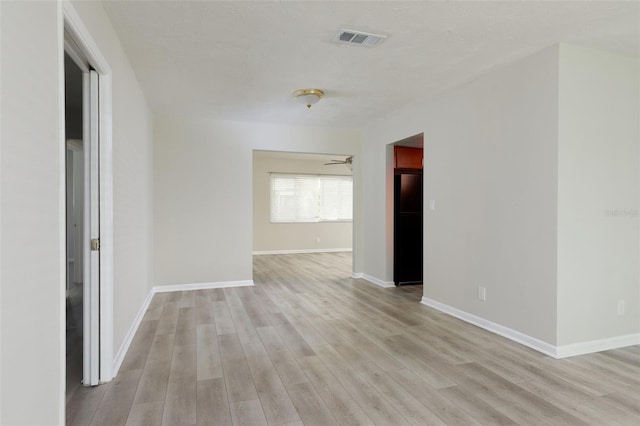 empty room with ceiling fan and light wood-type flooring