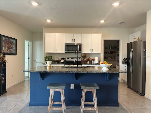 kitchen with white cabinetry, a kitchen island with sink, and appliances with stainless steel finishes