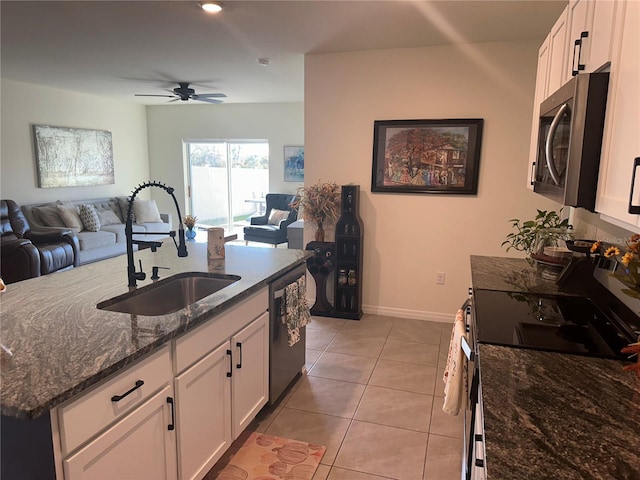 kitchen with white cabinets, sink, dark stone countertops, and stainless steel appliances