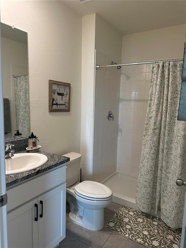 bathroom featuring vanity, a textured ceiling, tile patterned floors, and curtained shower