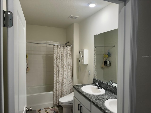 full bathroom featuring a textured ceiling, vanity, toilet, and shower / tub combo with curtain