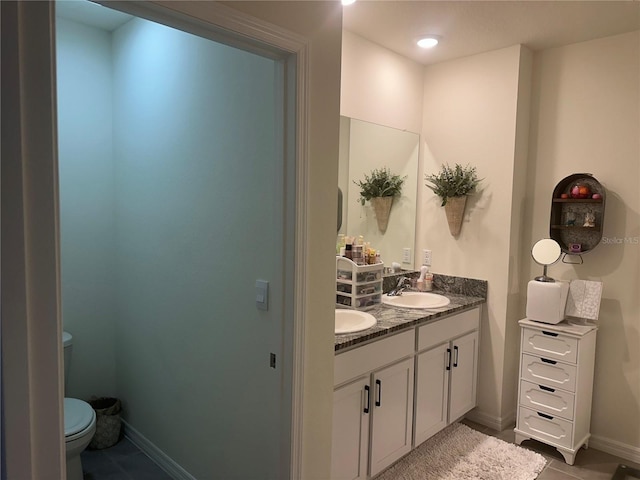 bathroom featuring tile patterned flooring, vanity, and toilet