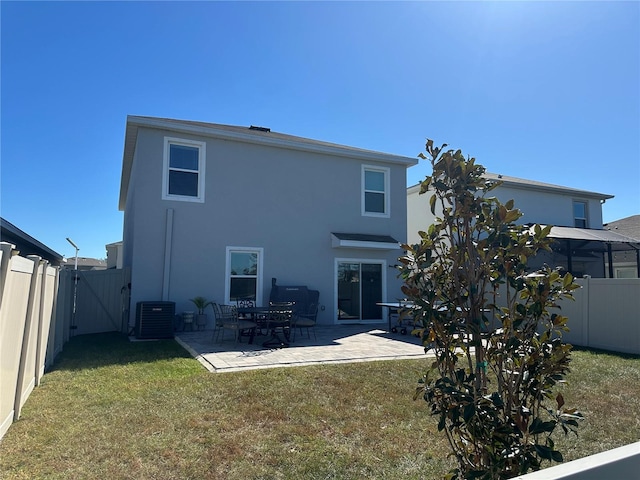 rear view of property featuring central AC unit, a patio area, and a yard