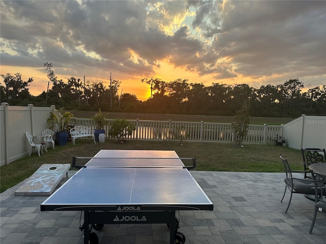 patio terrace at dusk featuring a yard