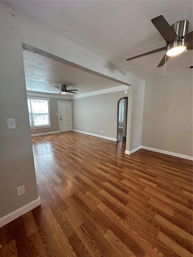 unfurnished living room featuring hardwood / wood-style flooring, ceiling fan, and a textured ceiling