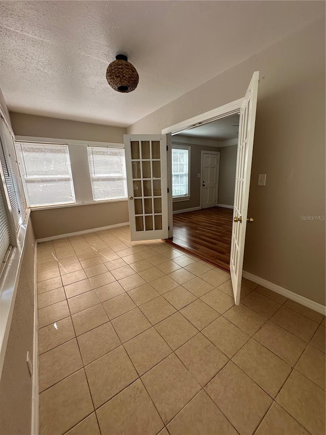 unfurnished room with a textured ceiling and light hardwood / wood-style flooring