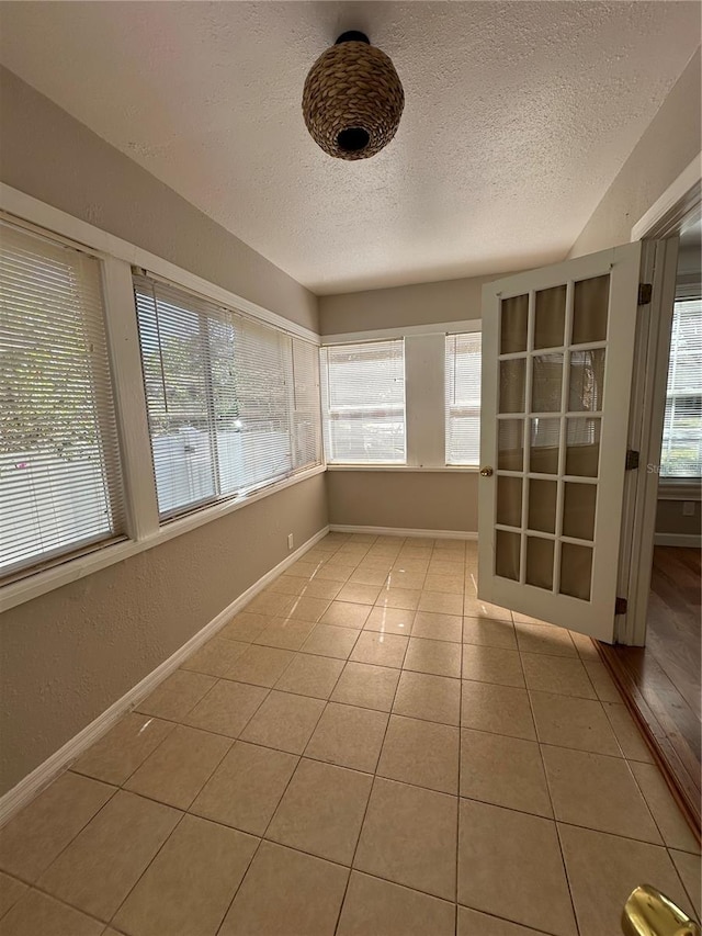 tiled spare room featuring a textured ceiling