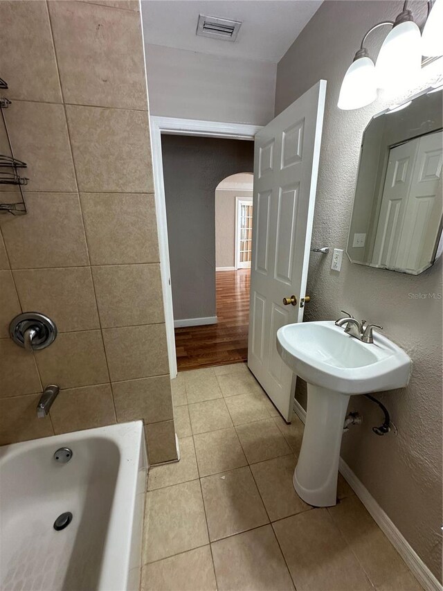 bathroom with tile patterned flooring and tiled shower / bath