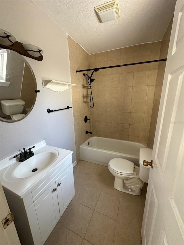 full bathroom featuring tile patterned floors, vanity, a textured ceiling, toilet, and tiled shower / bath