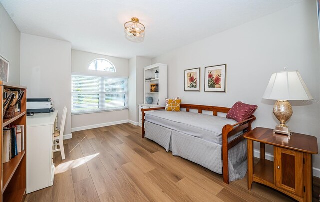 bedroom with light wood-style floors and baseboards