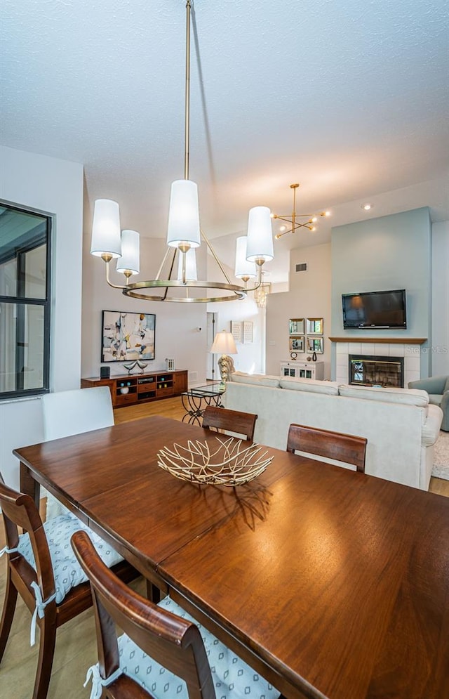 dining area with a tile fireplace and visible vents