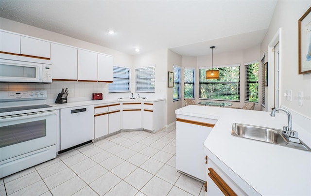 kitchen featuring white appliances, light tile patterned floors, light countertops, white cabinetry, and a sink