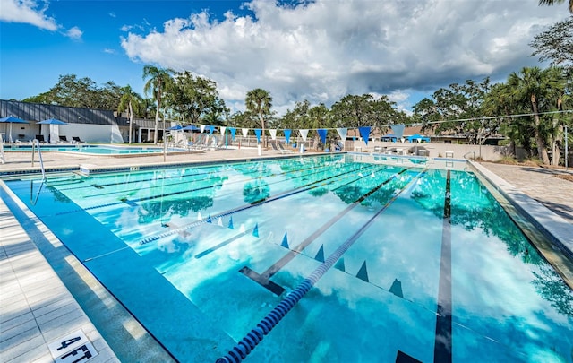 community pool with fence and a patio