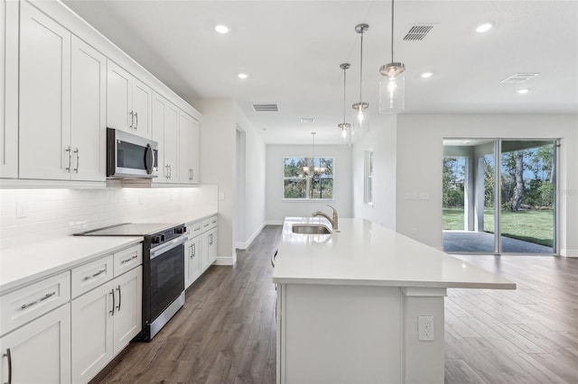 kitchen featuring white cabinets, stainless steel appliances, a kitchen island with sink, and sink