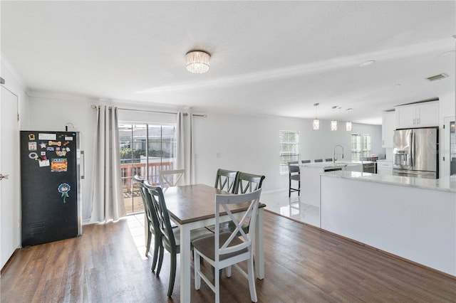 dining space with hardwood / wood-style floors and sink