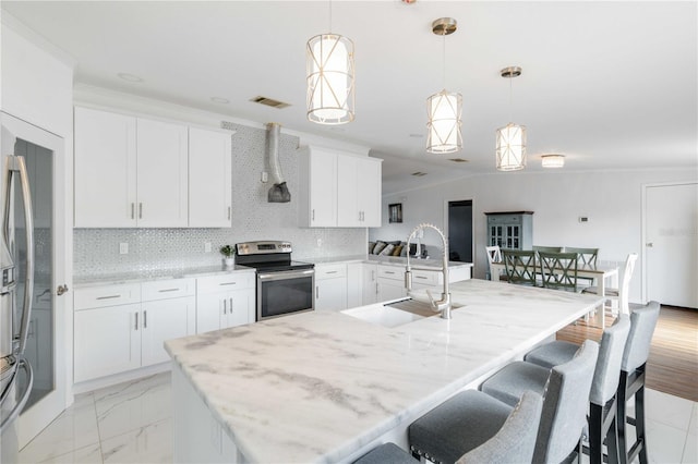 kitchen with pendant lighting, electric range, white cabinetry, and sink