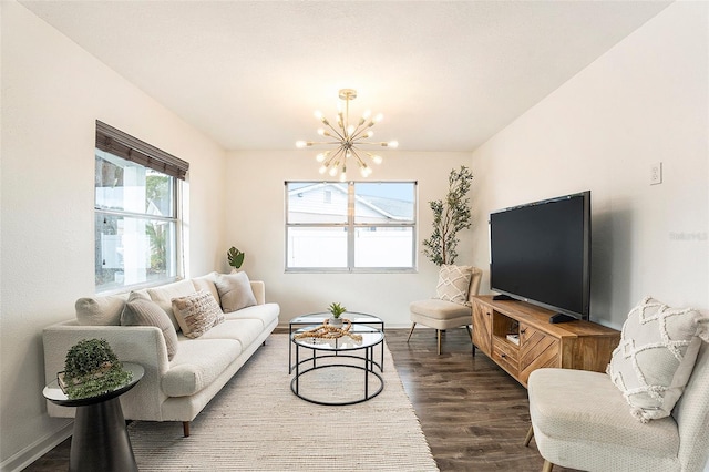 living area with wood finished floors, baseboards, and an inviting chandelier