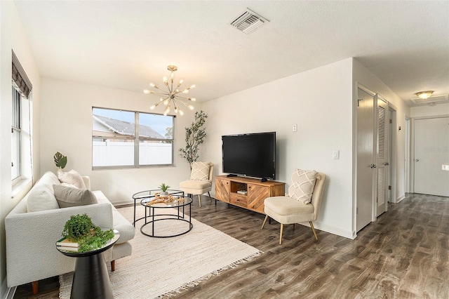 living room with dark wood-type flooring and an inviting chandelier