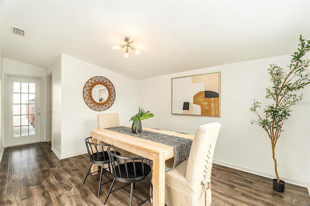 dining room with lofted ceiling, baseboards, visible vents, and dark wood finished floors