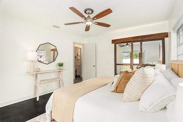 bedroom with dark wood-style floors, visible vents, baseboards, and a ceiling fan