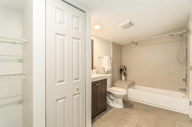 full bathroom featuring tile patterned flooring, vanity, toilet, and tiled shower / bath combo