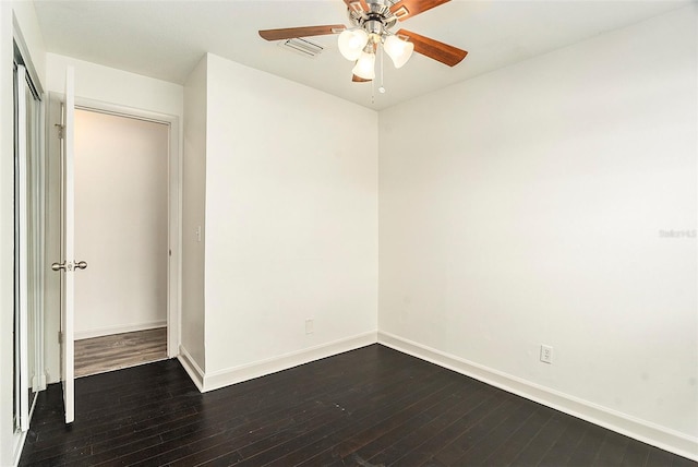 unfurnished bedroom featuring dark wood-style flooring, a ceiling fan, visible vents, baseboards, and a closet