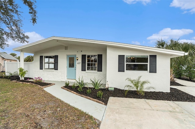 view of front of house with fence and stucco siding