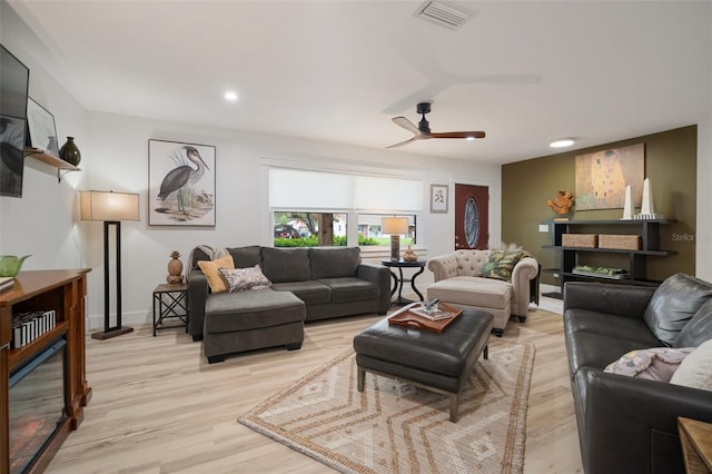 living room with light hardwood / wood-style flooring and ceiling fan