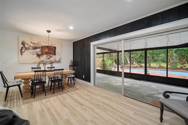 dining room with wood walls and light wood-type flooring