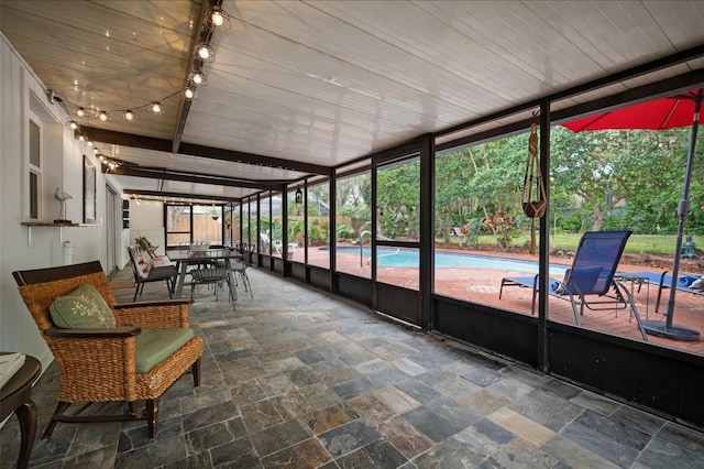 unfurnished sunroom featuring beam ceiling and wood ceiling