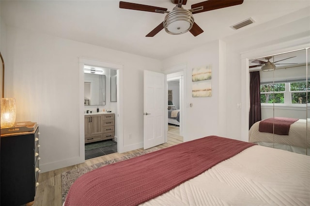 bedroom with hardwood / wood-style flooring, ceiling fan, and ensuite bathroom