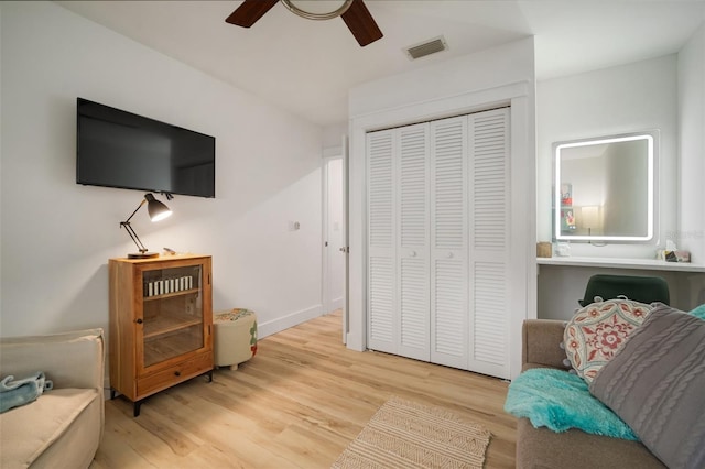 living area with ceiling fan and light wood-type flooring