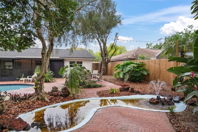 view of yard with a patio, a fenced in pool, and a sunroom